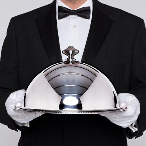 Waiter holding a silver cloche