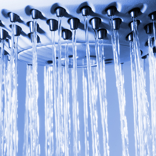 Water spraying from shower head with black jets